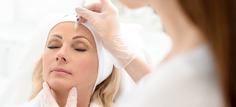 Woman getting Botox injections in the forehead