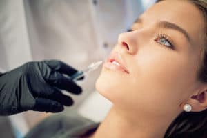Young woman getting botox injections to fix smile lines